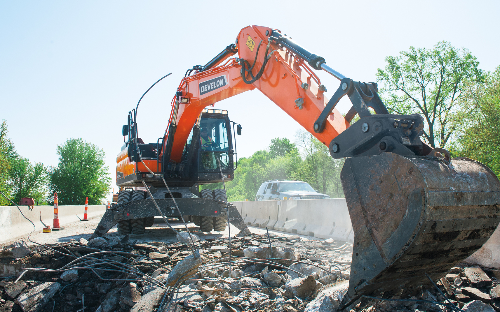 A DEVELON wheel excavator works on a bridge construction project.