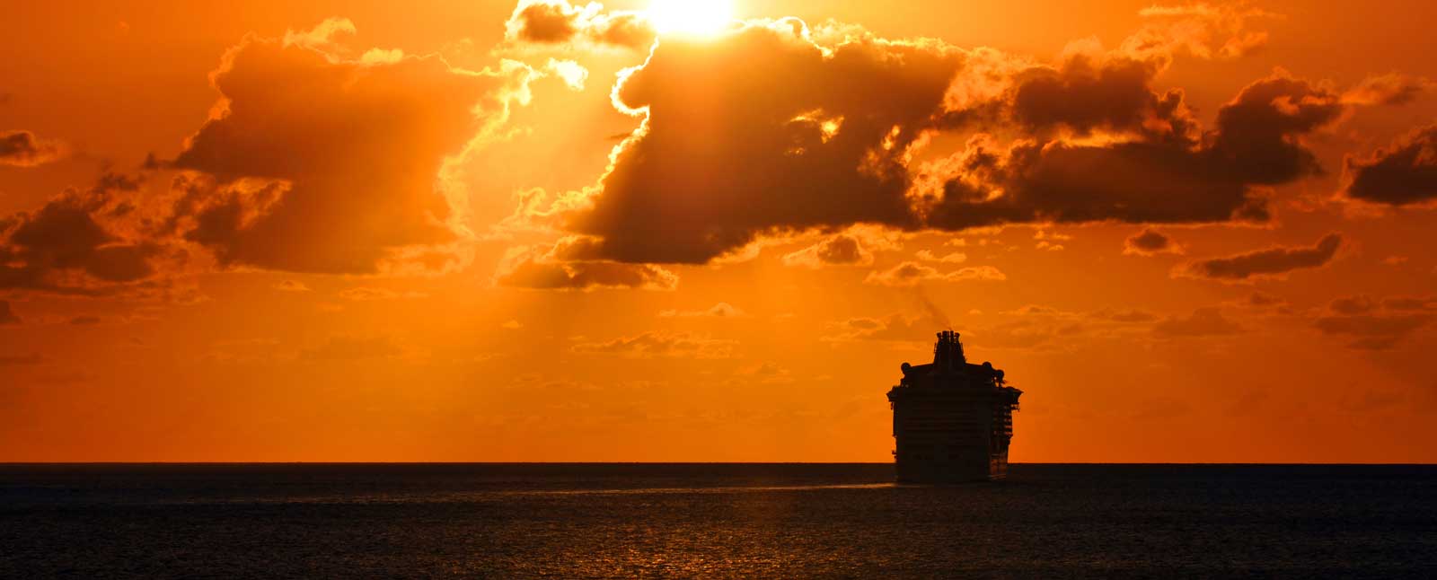 Large ocean liner on open ocean during sunset