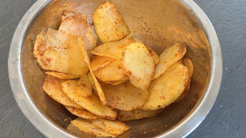 Potato slices seasoned in bowl