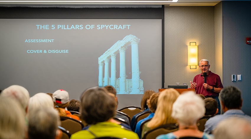 Kids and grandparents listening to a presentation about spycraft