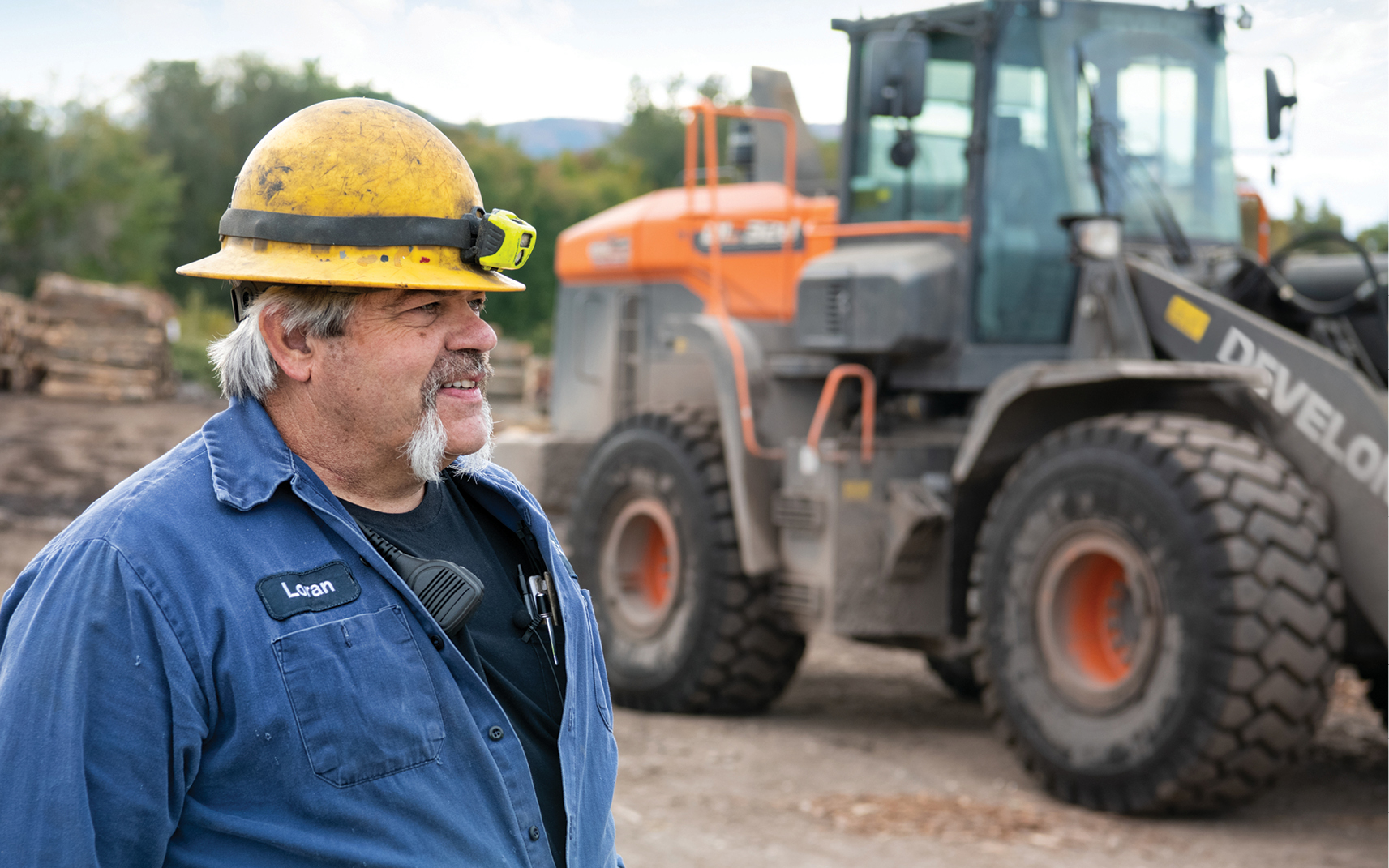 A picture of Loran McNally and a DEVELON wheel loader at the A. Johnson Company in Bristol, Vermont.