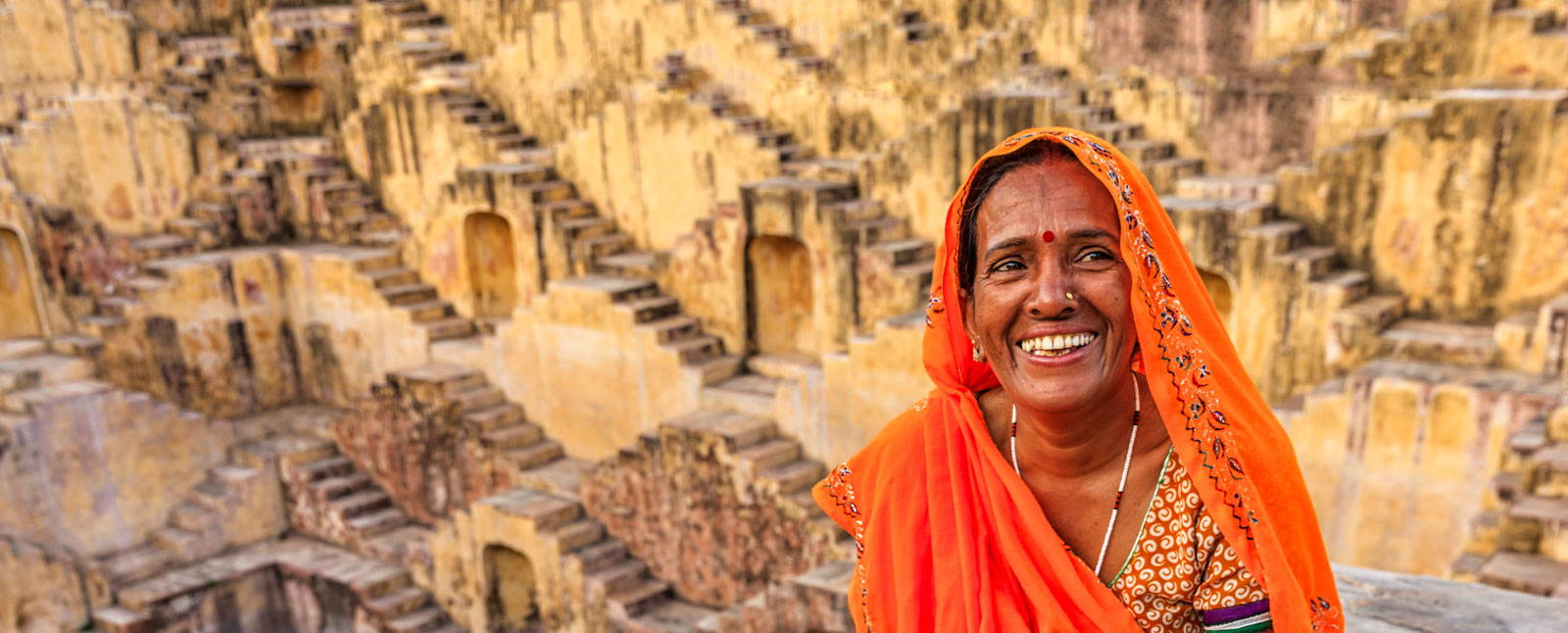 Indian woman resting inside stepwell in village near Jaipur, Rajasthan, India.