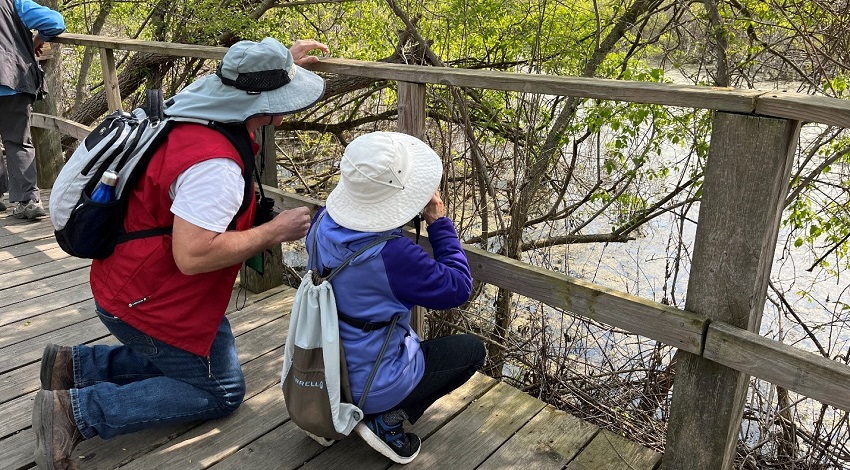 fined Alt	Two Road Scholar participants search for birds with binoculars