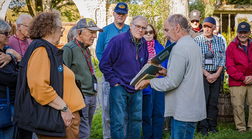 An instructor showing a book to a group of Road Scholars