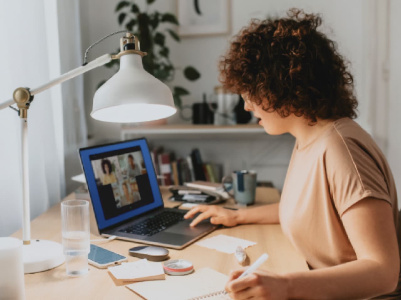 Woman working at desk with paper and laptop Woman working at desk with paper and laptop