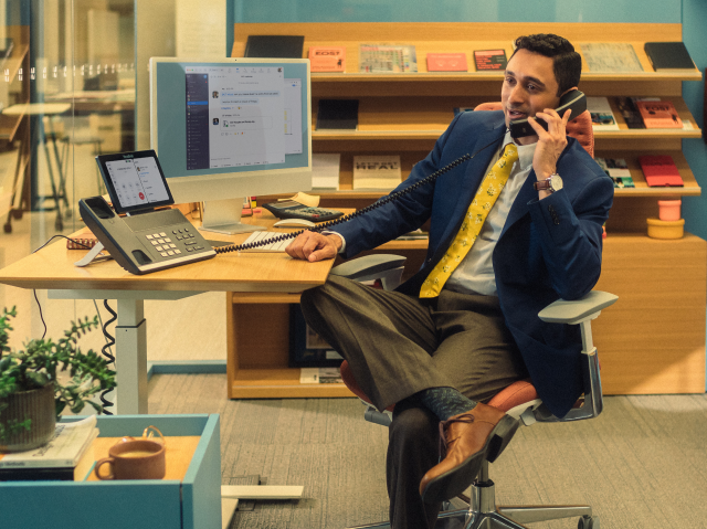 Man sitting as desk on phone