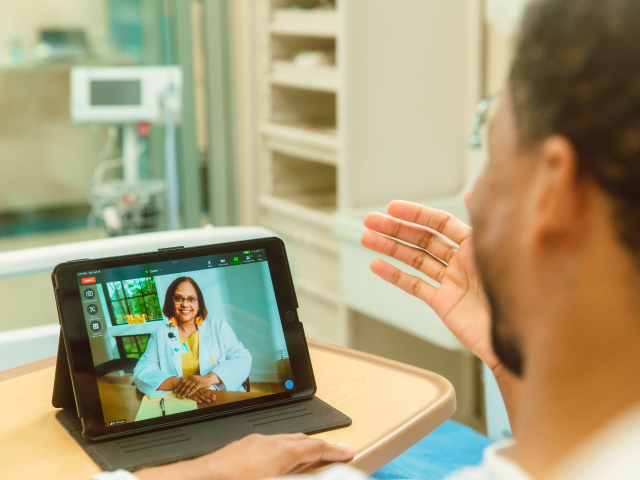 Doctor using tablet for zoom virtual meeting