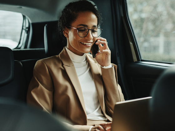 Woman in back of car on phone Woman in back of car on phone